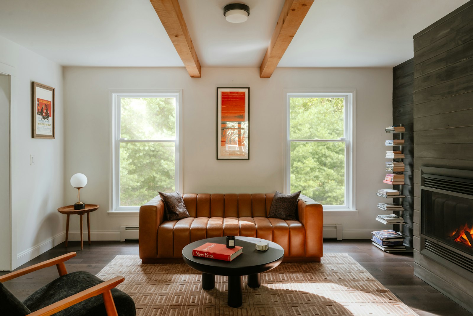 The Library, with bookshelves, a leather sofa, and afternoon light through tall windows.
